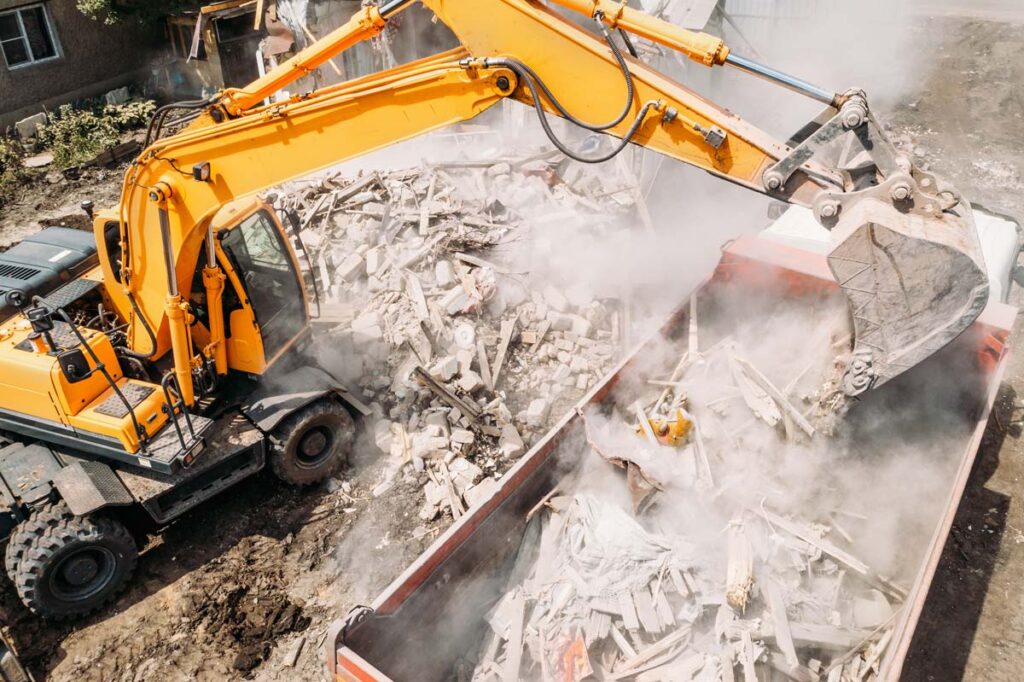 Excavator demolishing a building, representing the M&M Rentals D Street apartments class action lawsuit settlement.