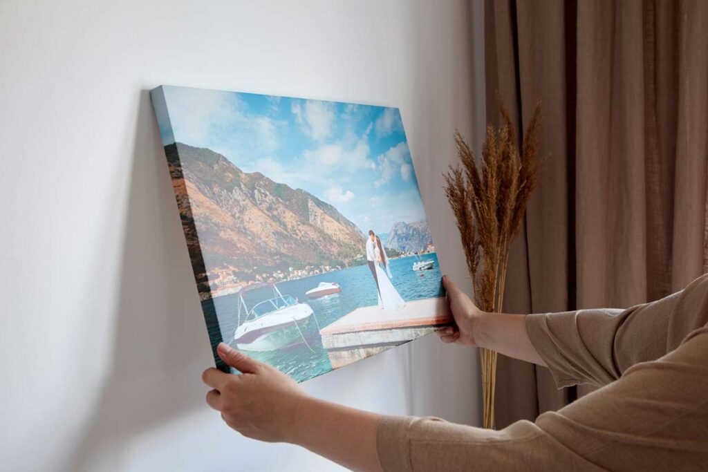 Close up of a woman hanging a custom canvas print, representing the iCanvas lawsuit.