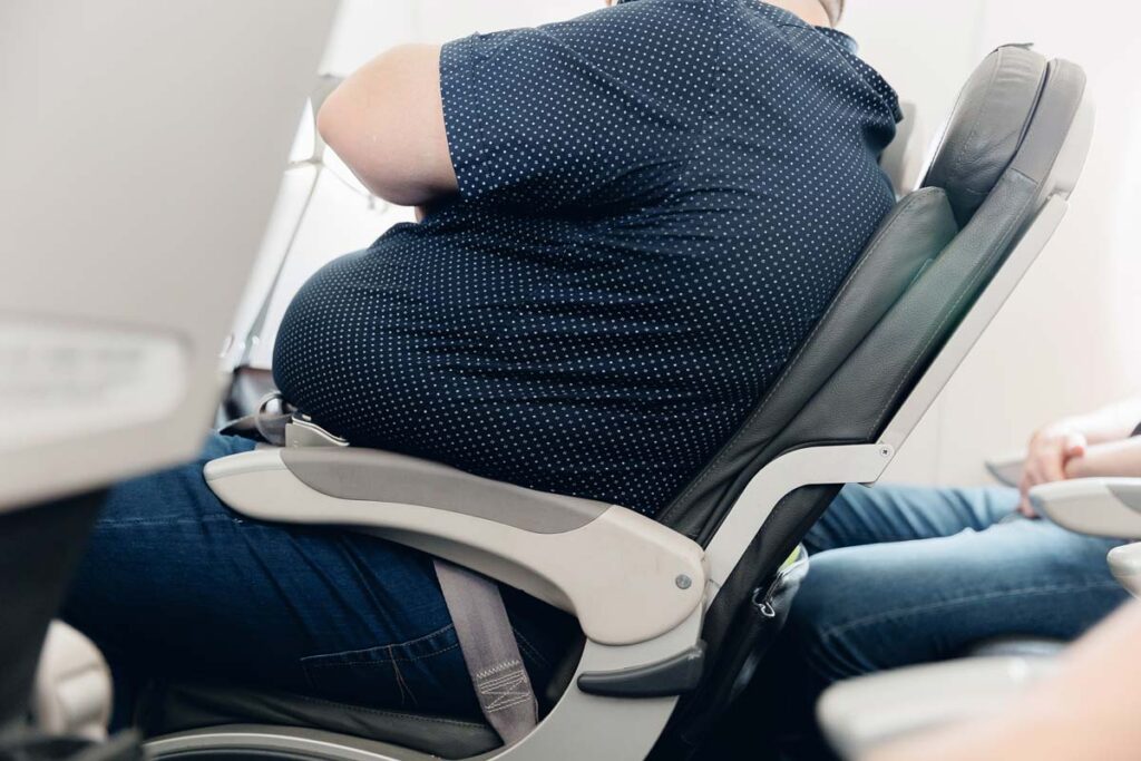 A plus size male sitting in an airline seat, representing the airline weight and fuel study.