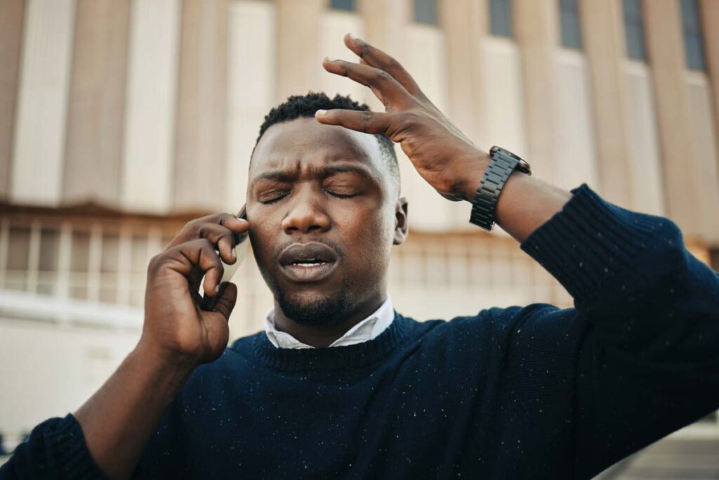 Close up of a stressed male talking on the phone, representing the Freedom Financial Network and Freedom Debt Relief class action lawsuit settlement.
