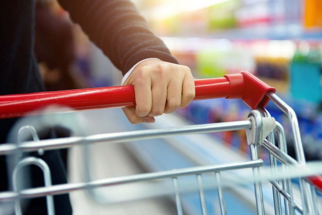 Close up of a hand pushing a shopping cart, representing the top recalls for the week of Oct. 23.