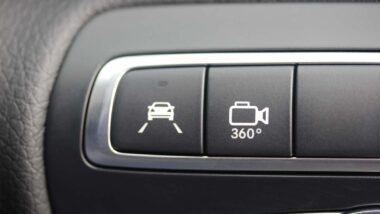 Close up of a 360 camera button on a steering wheel, representing the Ford 360-Degree Camera class action.