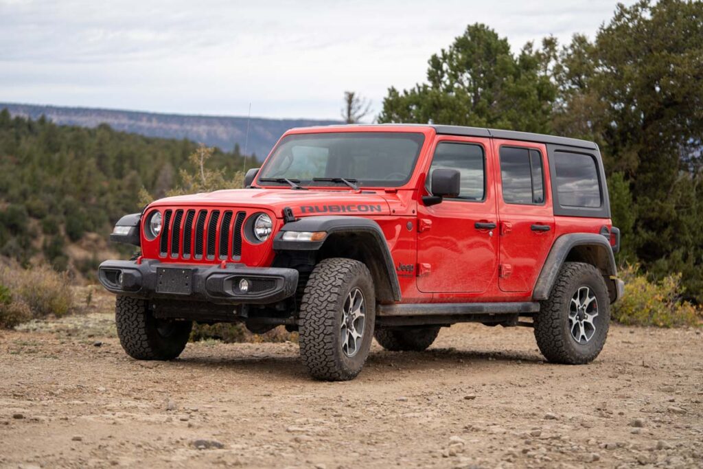 A red Jeep Wrangler parked on a dirt road, representing the Jeep clutch defect class action.