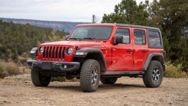 A red Jeep Wrangler parked on a dirt road, representing the Jeep clutch defect class action.