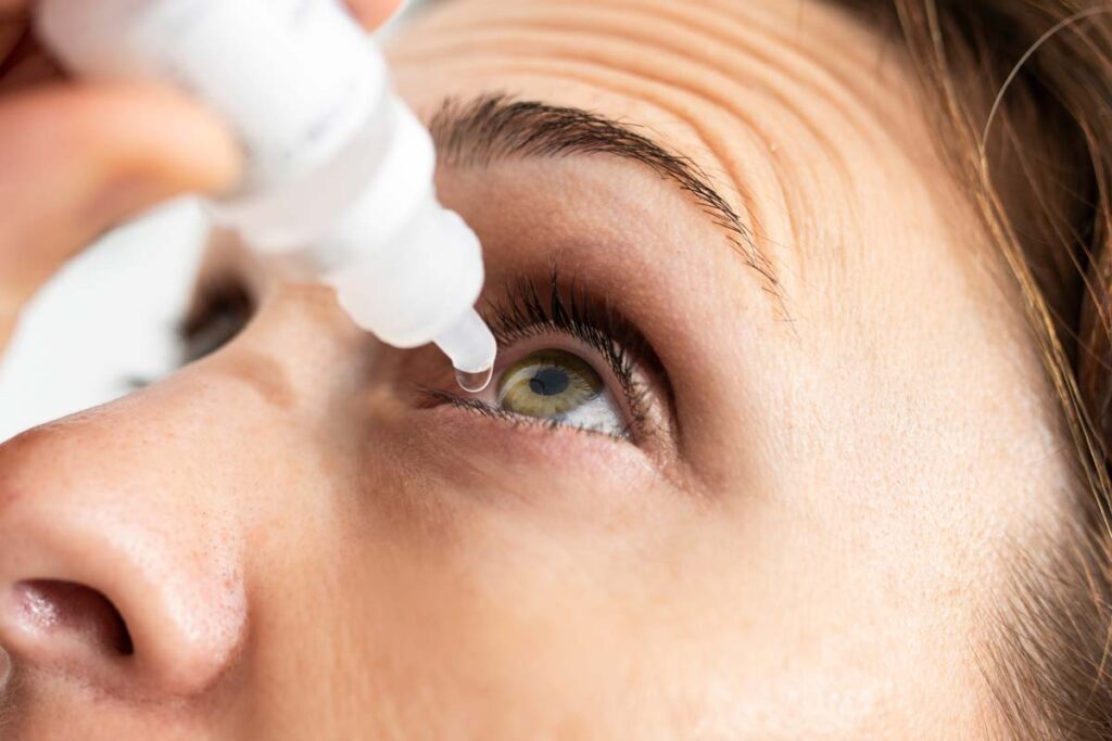 Close up of a woman putting eye drops in her eyes, representing the FDA eye drop warning.