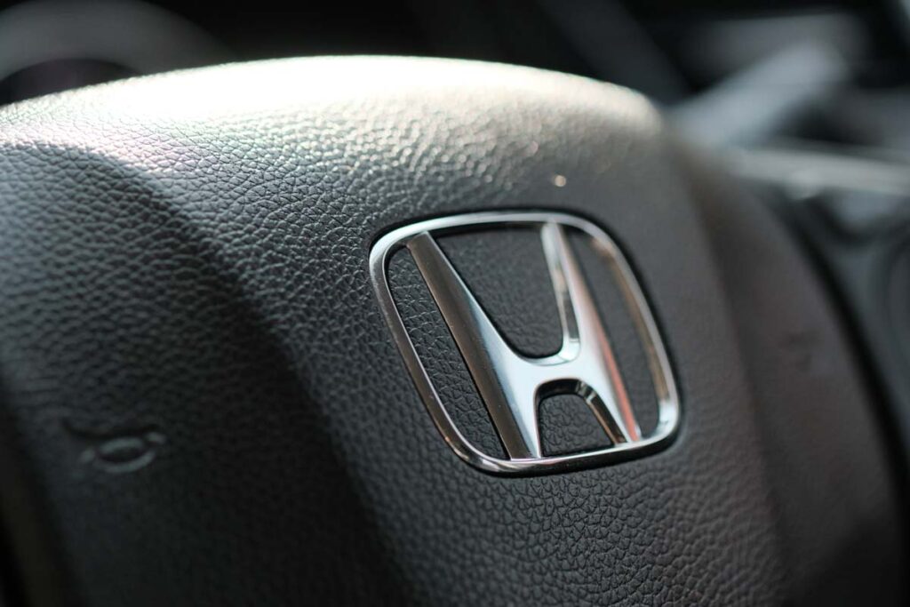 Close up of Honda emblem on a steering wheel, representing Honda recalls.