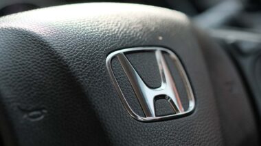 Close up of Honda emblem on a steering wheel, representing Honda recalls.