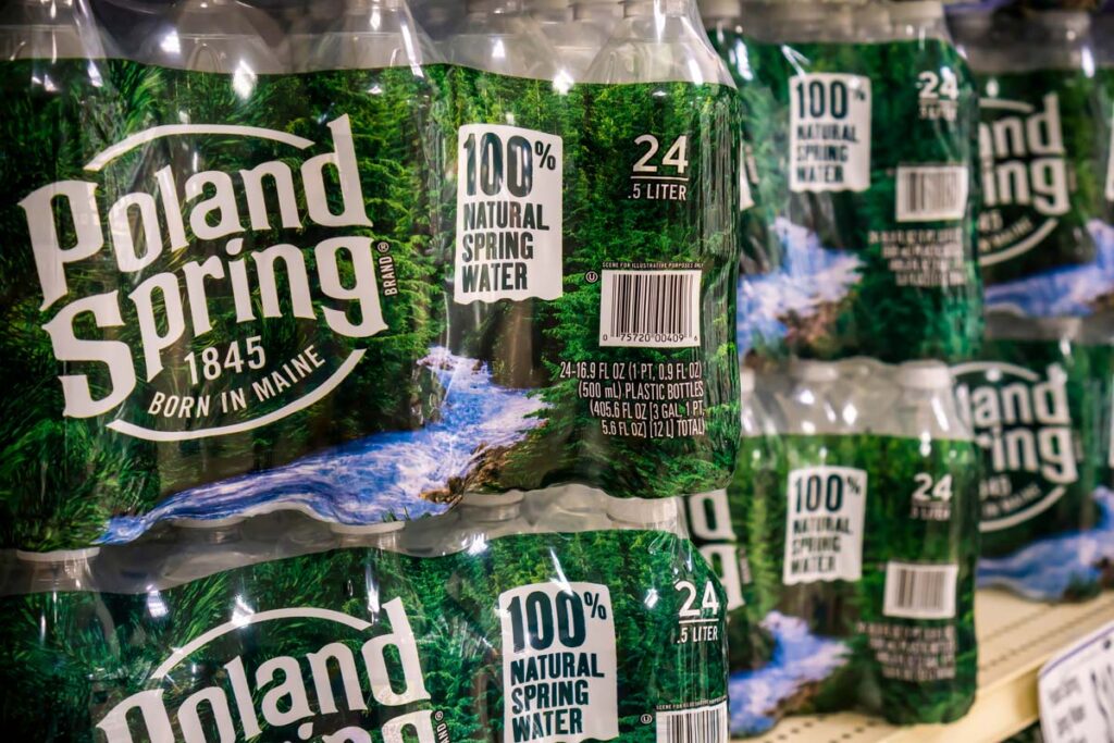 Packaged Poland Springs water bottles on a grocery store shelf, representing the Poland Spring false advertising lawsuit.