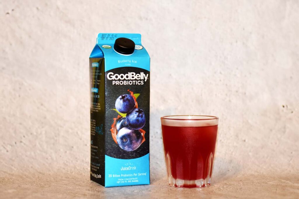 GoodBelly product next to a cup filled with juice, representing the GoodBelly class action lawsuit settlement.