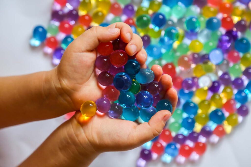 Close up of hands holding water beads, representing the end of Amazon, Target and Walmart water beads sales.