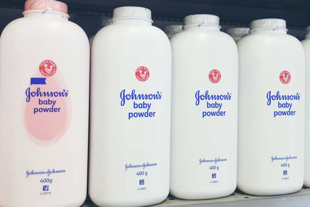 Johnson & Johnson baby powders on a supermarket shelf, representing the Johnson & Johnson talc baby powder settlement.