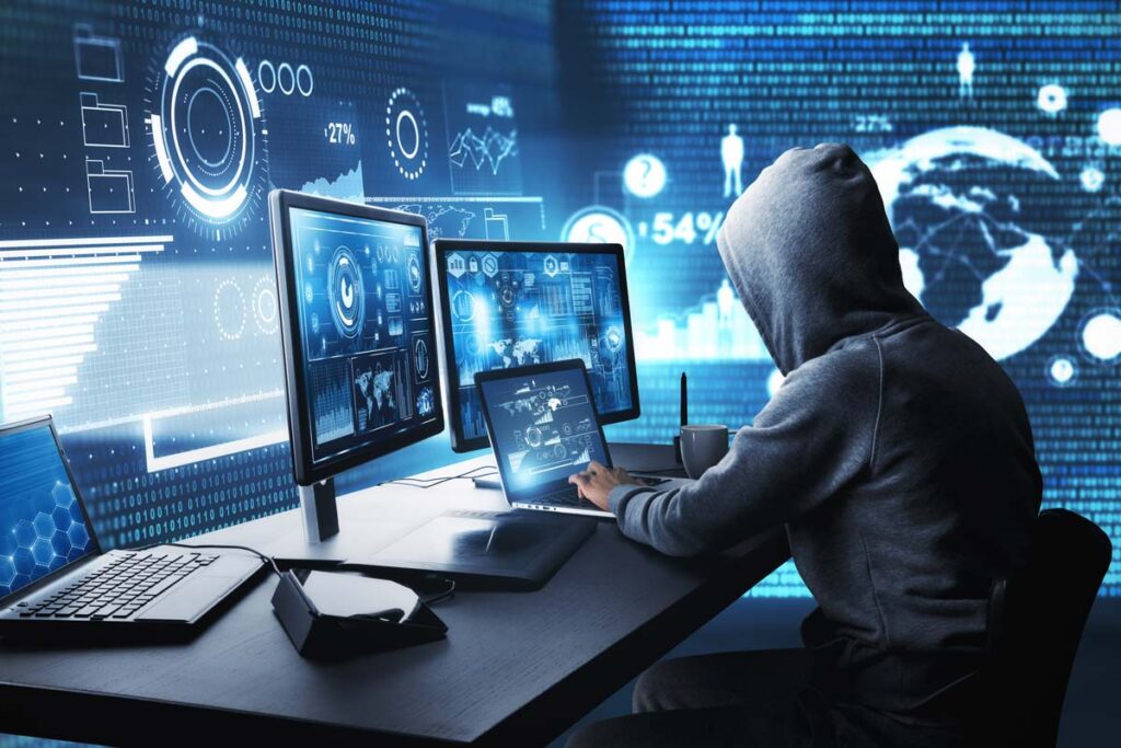 Hooded hacker using a computer, representing the P2ES Holdings data breach settlement.