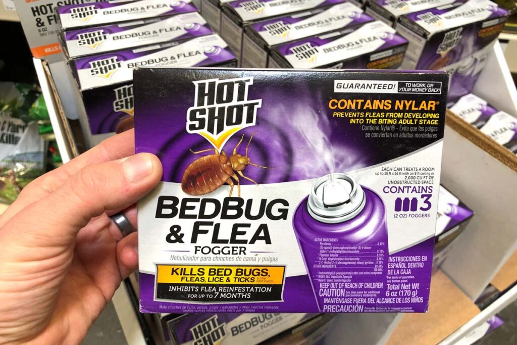 Hand holding a box of Hot Shot Beg Bug & Flea Fogger, representing the Hot Shot bedbug pesticide class action.