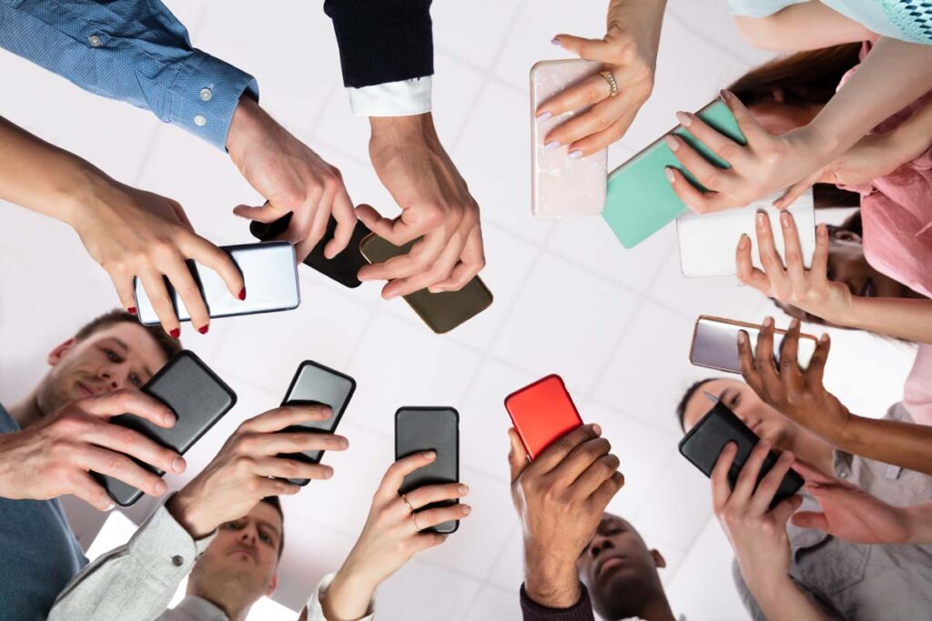 Group of people standing in a circle using their smartphones, representing the massive data breach.