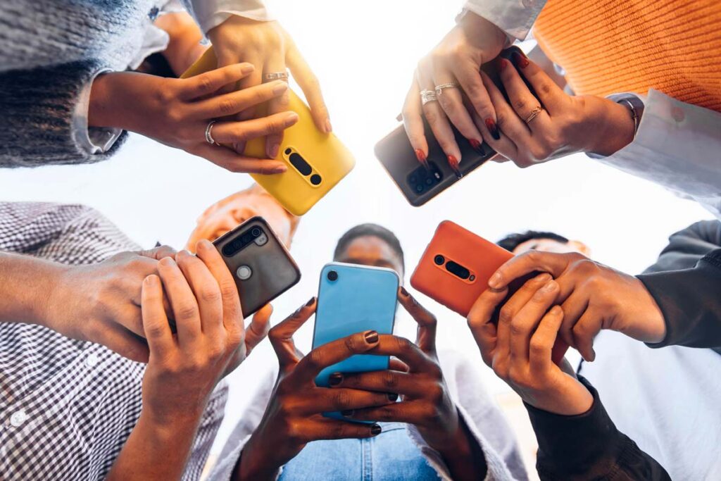 Teens in a circle using their smartphones, representing the Meta teen settings.
