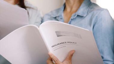 Close up of a woman holding an insurance policy booklet, representing the Benefytt insurance settlement.