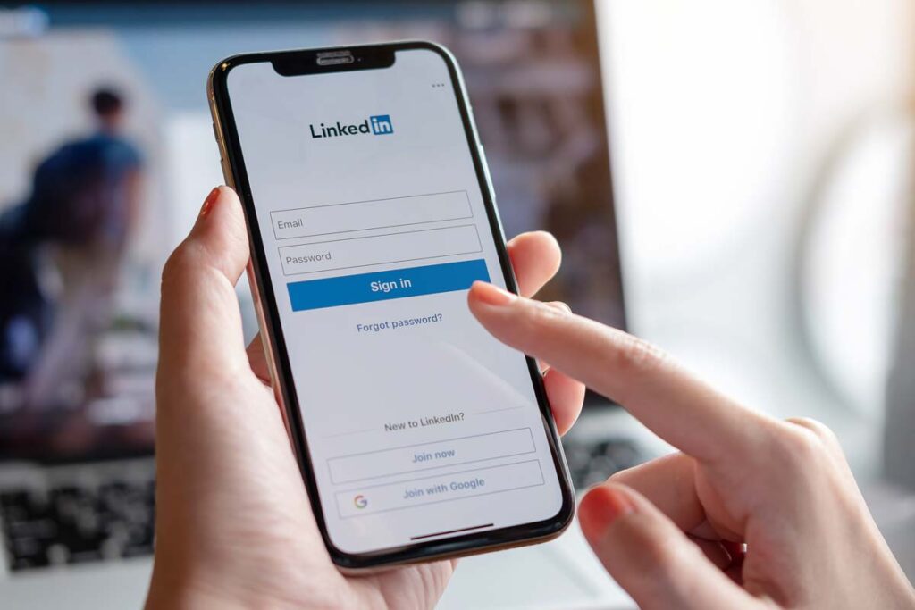 Close up of a woman logging into LinkedIn on a smartphone, representing the LinkedIn class action.