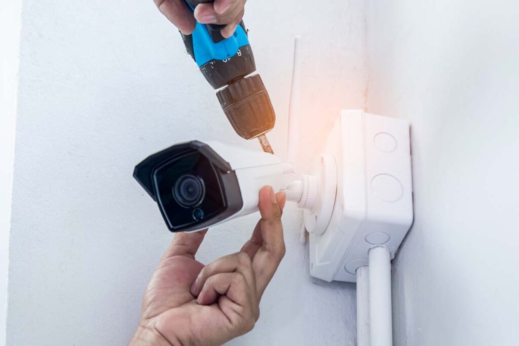 Close up of a man installing a WiFi camera, representing the Waze data breach affecting customers' homes.