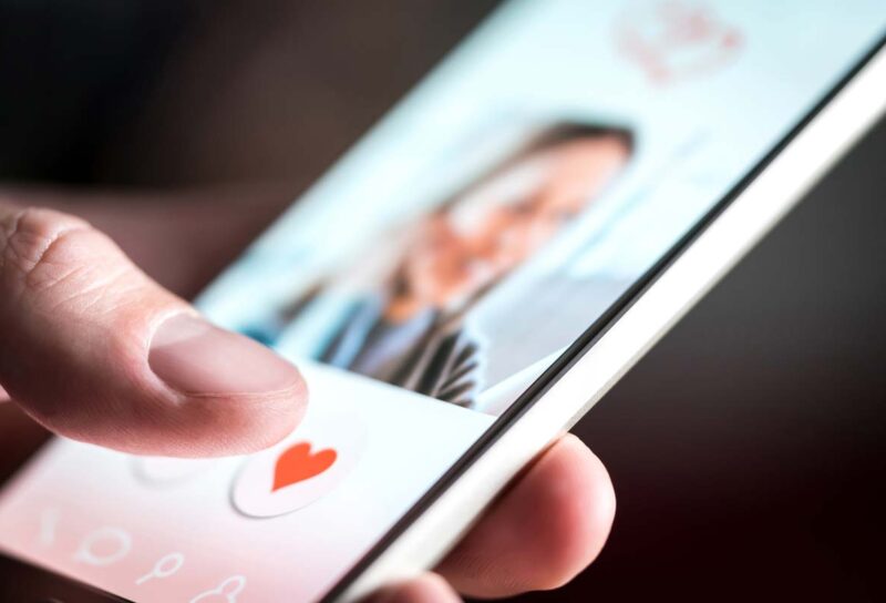 Close up of a woman using a data app on her smartphone, representing the Tinder and Hinge class action.