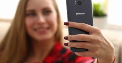 A woman taking a selfie on a Samsung phone, representing Samsung biometric data arbitration.