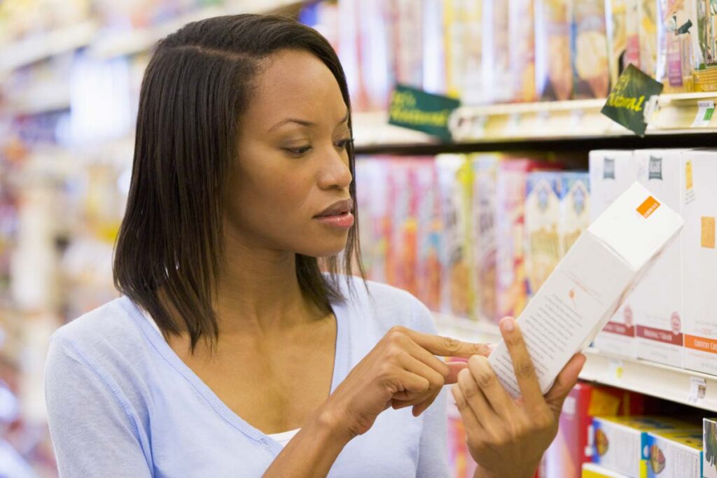 A woman examining a product in a supermarket, representing false advertising lawsuits.
