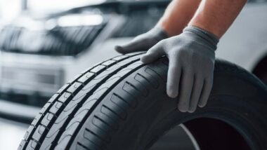 Close up of a mechanic with his hands on a new tire, representing the tire class action.