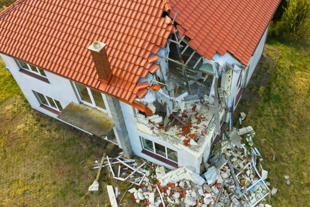 Aerial view of a home with structural damage, representing the Auto-Owners (Mutual) Insurance class action lawsuit settlement.