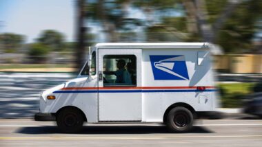 A USPS worker driving a USPS vehicle, representing the USPS class action lawsuit.