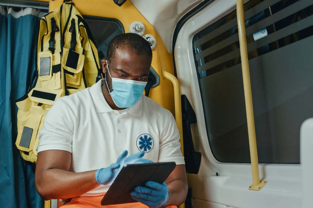 Close up of a male EMS worker using a tablet, representing the Empress Ambulance Service settlement.