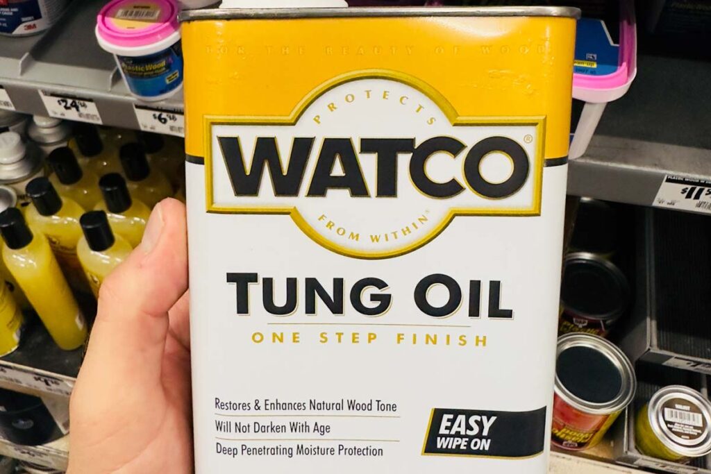 Close up of hand holding Watco Tung Oil product, representing the Rust-Oleum class action lawsuit.