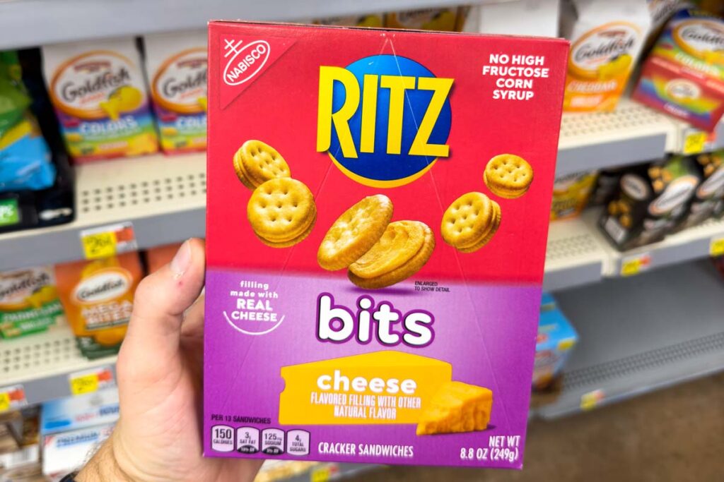 Close up of hand holding Ritz Bits Cracker Sandwiches in a grocery store, representing the Ritz class action lawsuit.