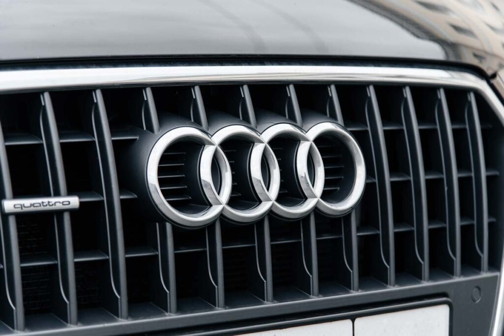 Closeup of an Audi emblem on a front auto grille, representing the Audi oil consumption class action lawsuit settlement.