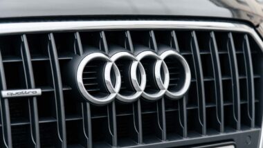 Close up of Audi emblem on a front auto grille, representing the Audi oil consumption settlement.