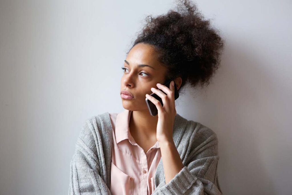 A serious woman on a phone call, representing AI robocalls.