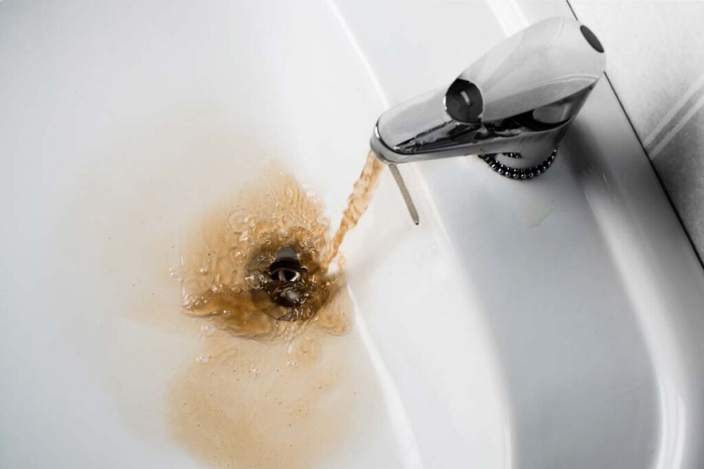 Dirty water running from a sink faucet, representing the Flint settlement.