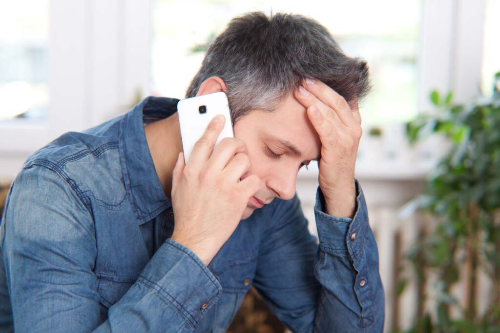 Close up of a stressed man on a phone call, representing the FiveStrata and First American settlement.