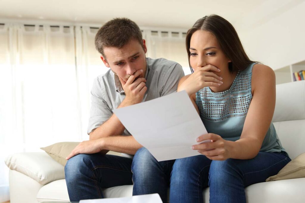 A worried couple reading a notice letter about their account, representing the Vivint home security false accounts FCRA class action lawsuit settlement.