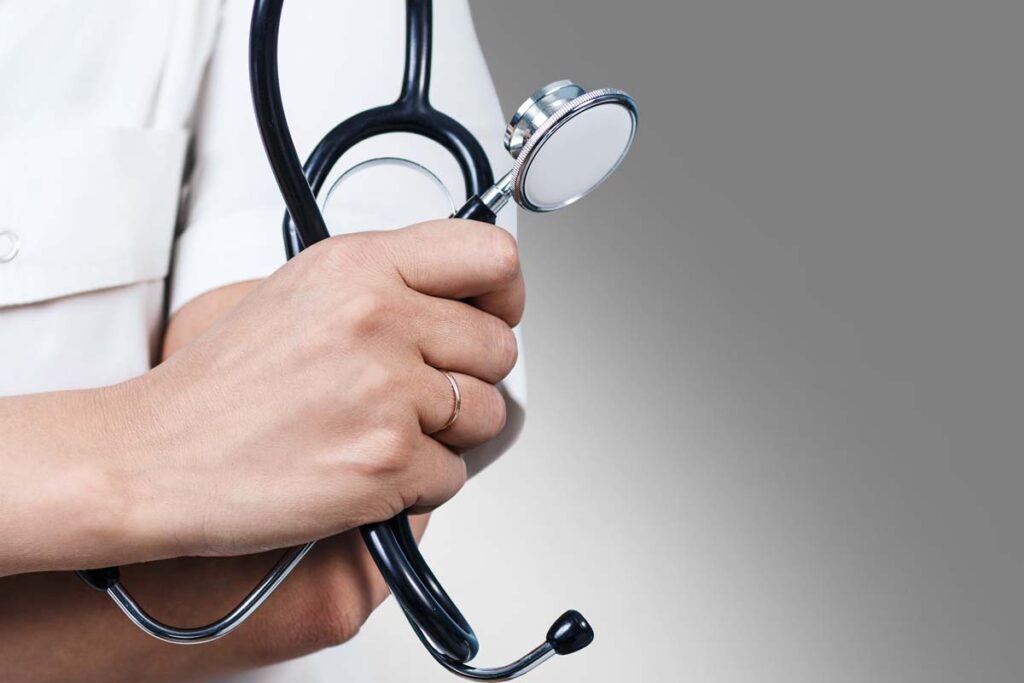 Close up of a doctor holding a stethoscope, representing the QC Kinetix class action lawsuit.