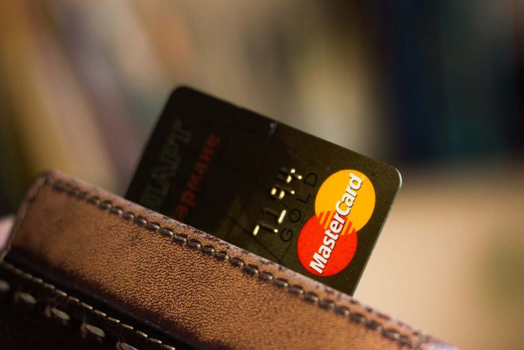 Mastercard credit card peeking out of a wallet, representing the Amazon and Mastercard settlement.