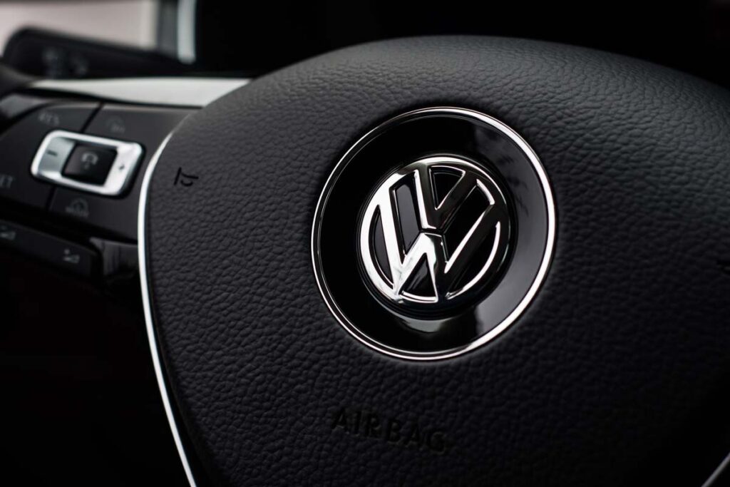 Closeup of VW emblem on a steering wheel, representing the VW vehicle fuel leak recall.