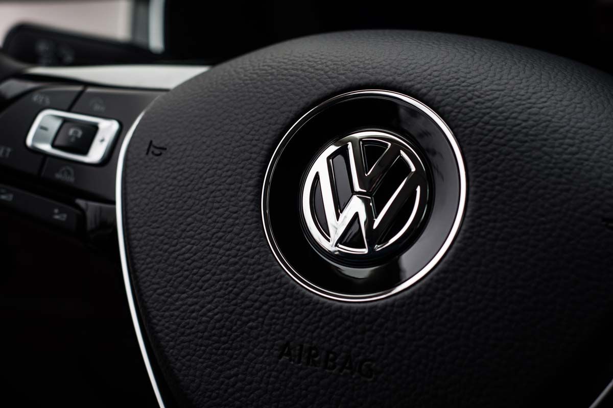 Close up of VW emblem on a steering wheel, representing the VW recall.