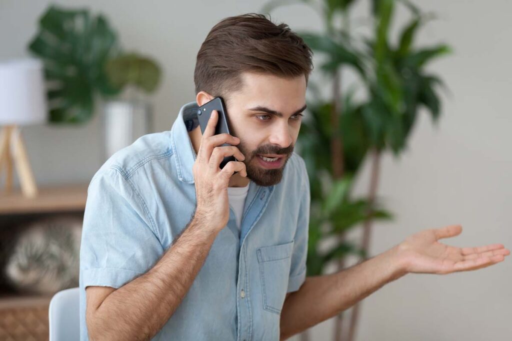 An irritated man talking on the phone, representing the North Star Insurance Advisors telemarketing class action settlement.