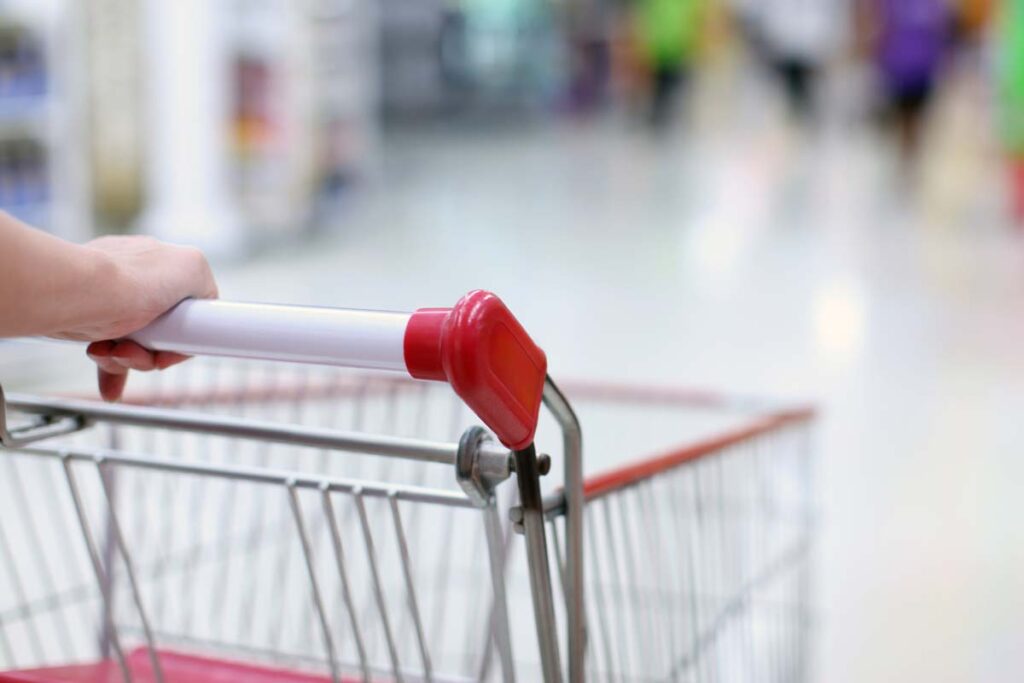 Close up of a person pushing a shopping cart in a supermarket, representing top recalls for the week of Feb. 26.