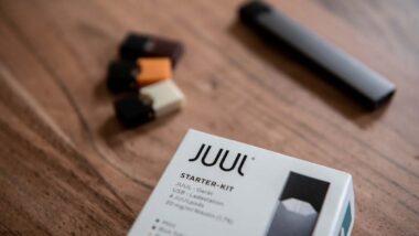 Close up of Juul starter kit on a wood table, representing the Altria settlement.