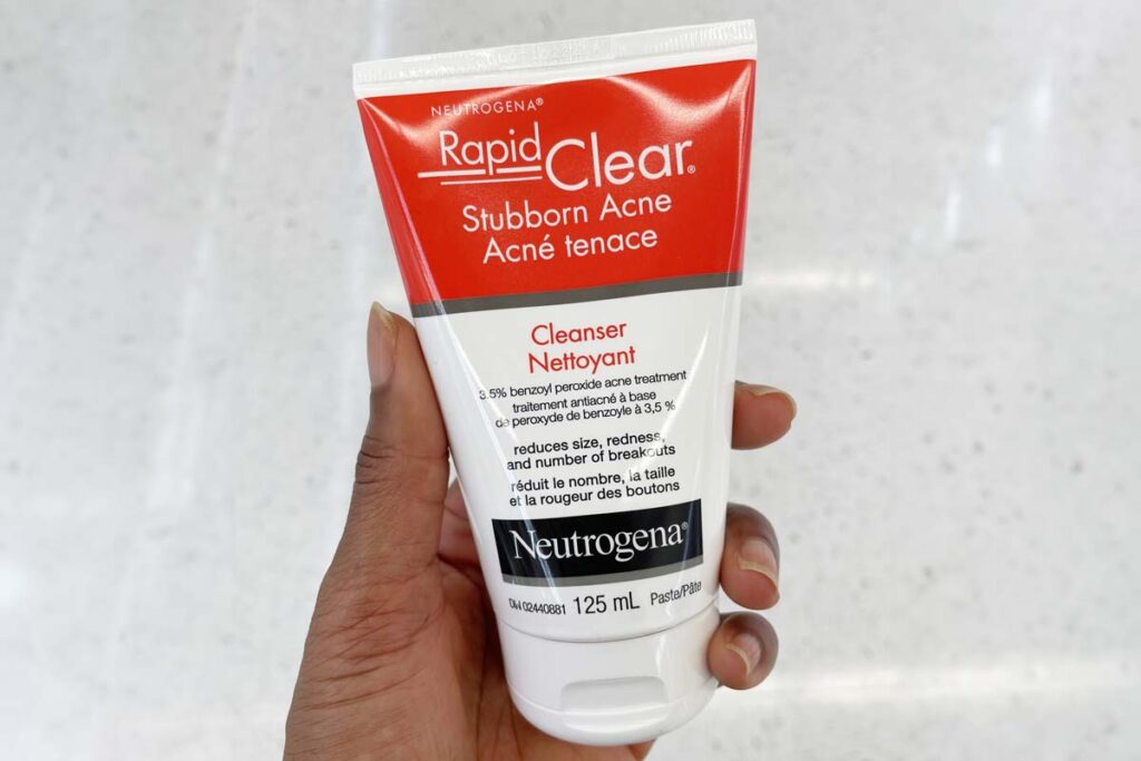Close up of a hand holding a Neutrogena benzoyl peroxide product, representing the Neutrogena class action.