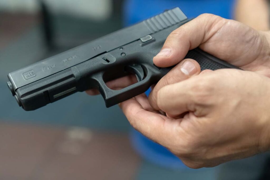 Close up of a man holding a Glock pistol, representing the Glock lawsuit.
