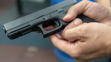 Close up of a man holding a Glock pistol, representing the Glock lawsuit.