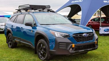A blue 2021 Subaru Outback at a car show, representing the Subaru recall.