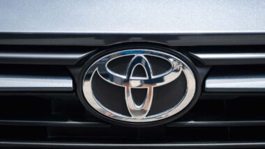 Close up of a Toyota emblem on a front bumper, representing the Toyota settlement.