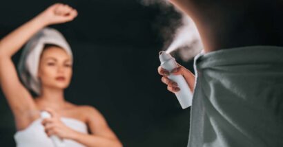 A woman using aerosol deodorant in the mirror, representing the Suave benzene settlement.